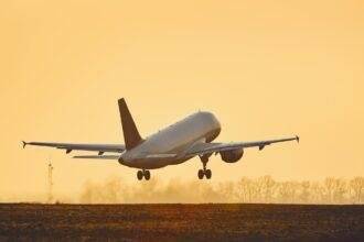 Airplane taking off at sunset