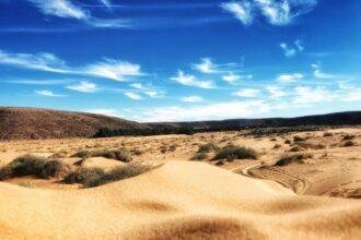 brown sand under blue sky and white clouds during daytime