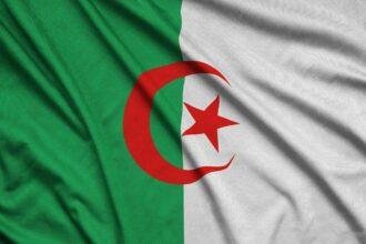 Algeria flag is depicted on a sports cloth fabric with many folds. Sport team waving banner