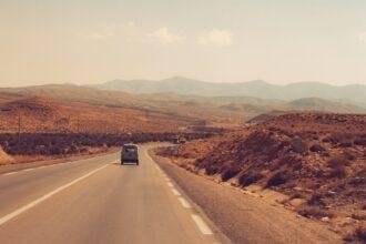 a truck driving down a road in the desert